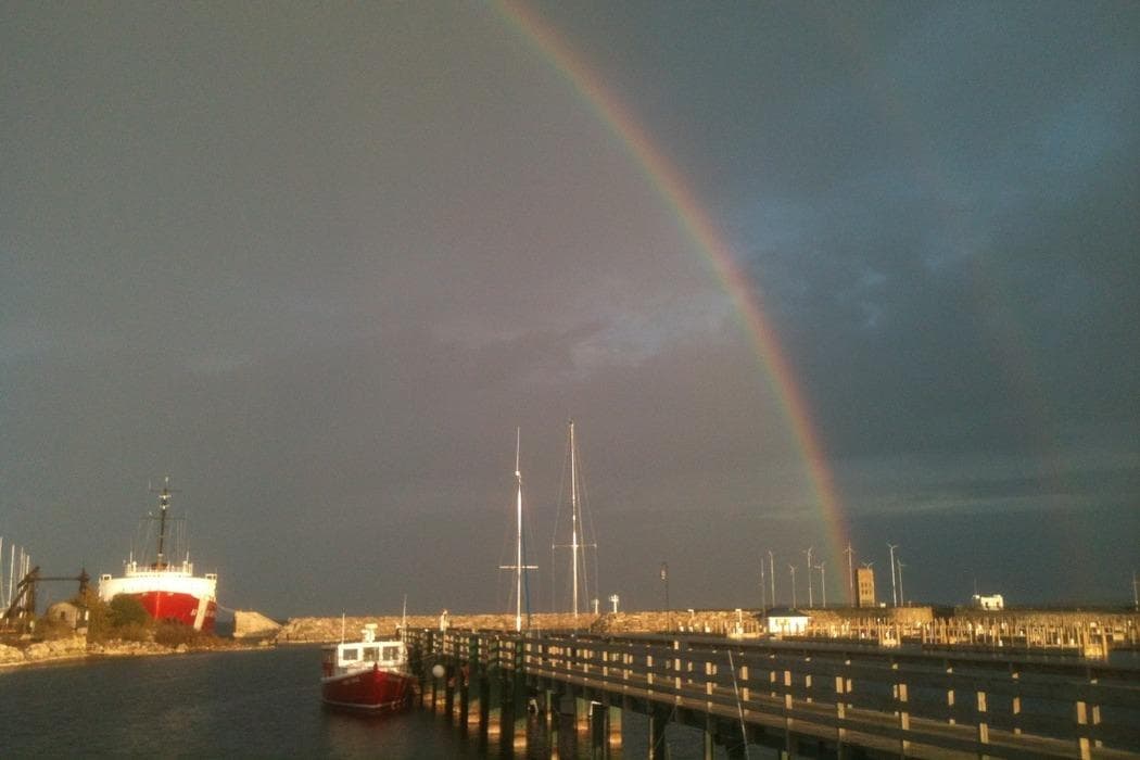 Harbor rainbow over marina with boats in Mackinac waters