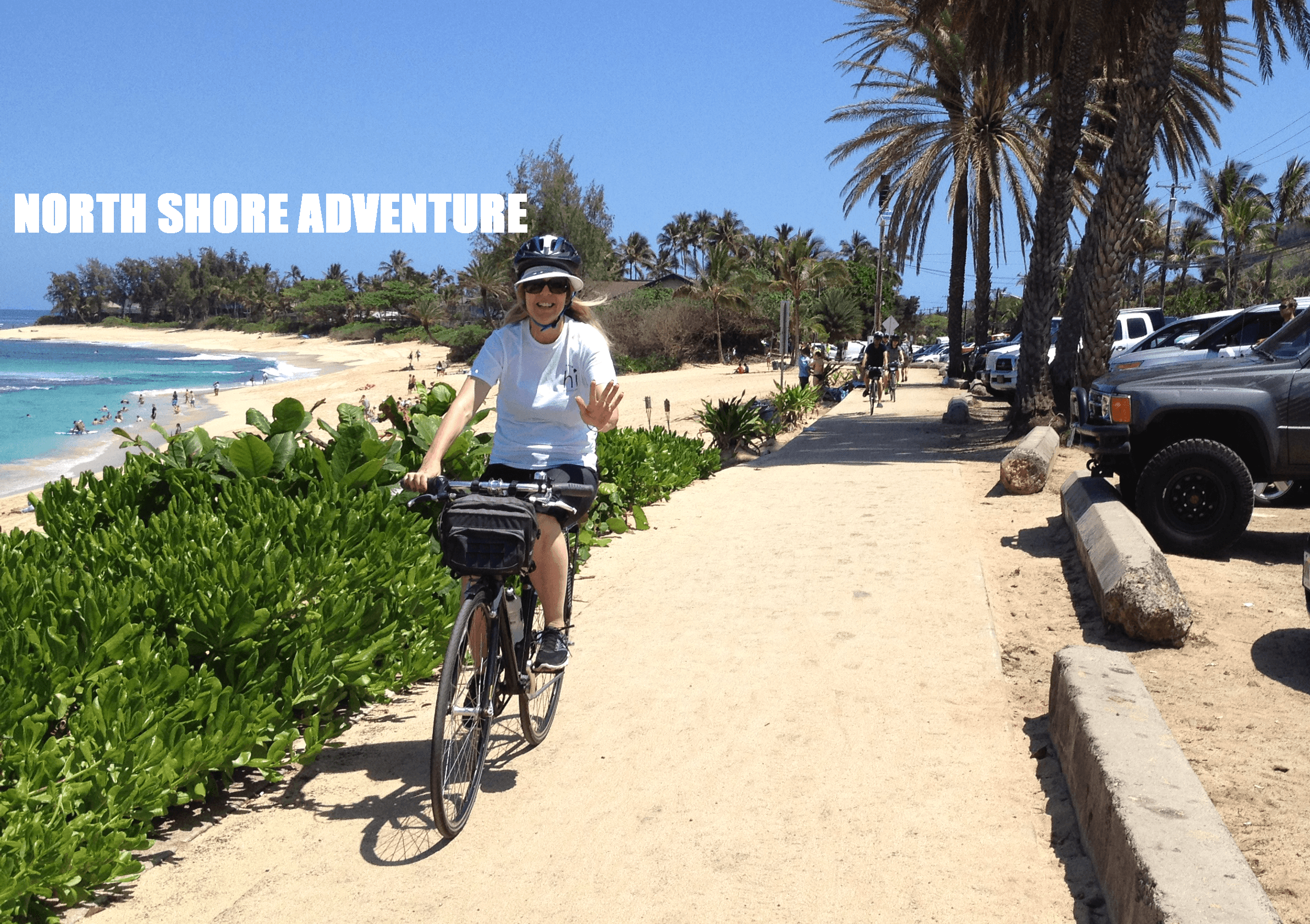 Cyclist riding along sandy North Shore beach path in Oahu