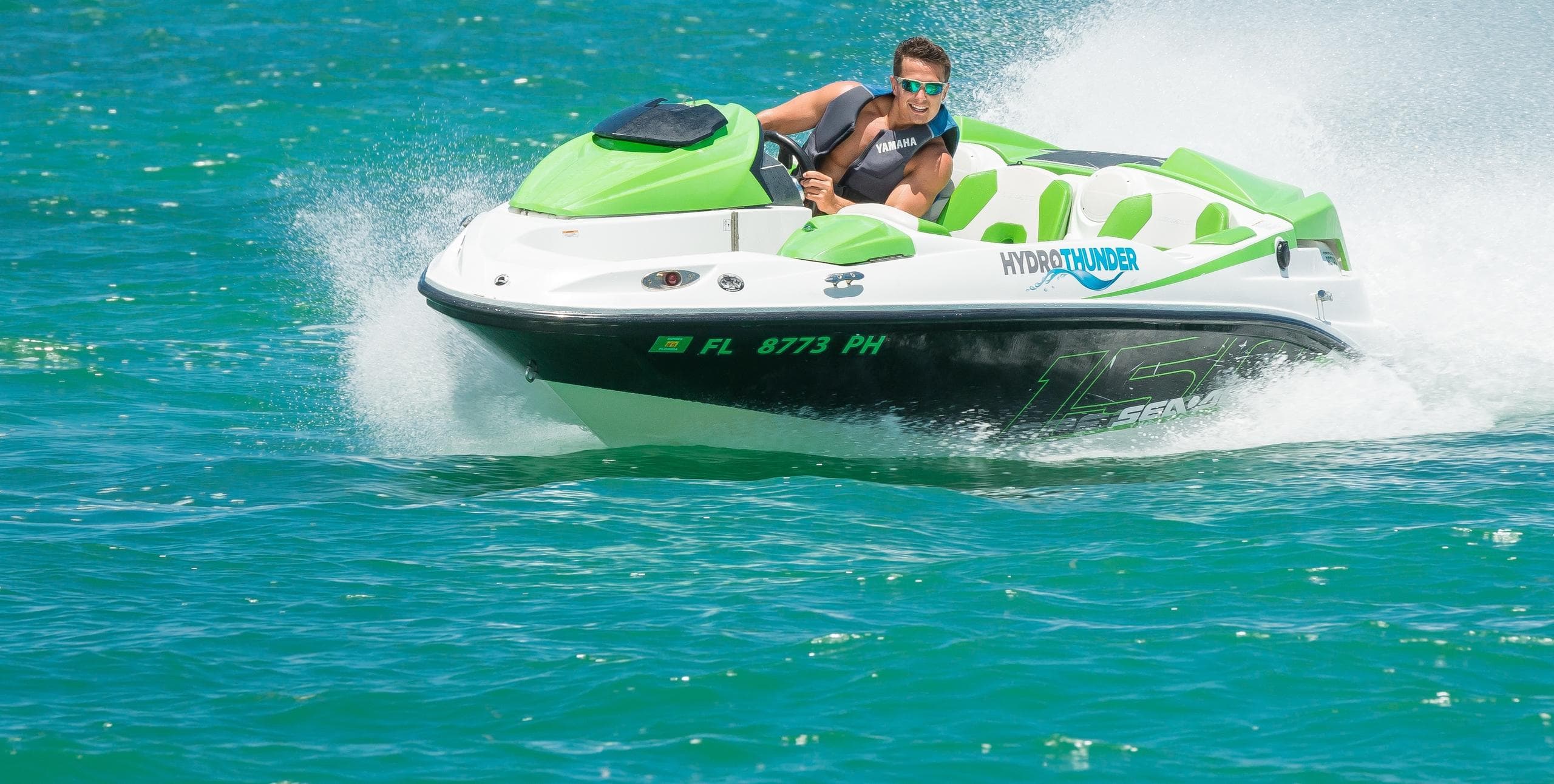 Green jet boat speeding across clear turquoise Key West waters