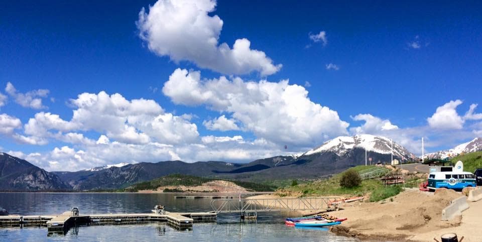 Scenic mountain lake panorama with paddleboards on shore