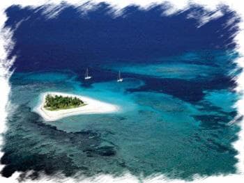 Aerial view of tiny tropical island and turquoise lagoon