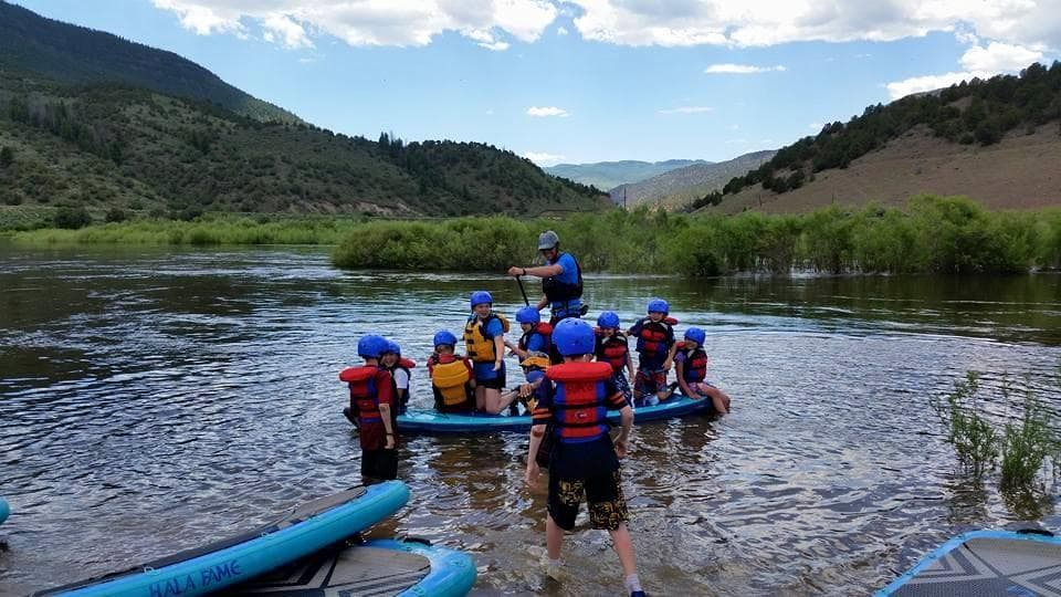 Guided paddle and rafting group entering calm river valley