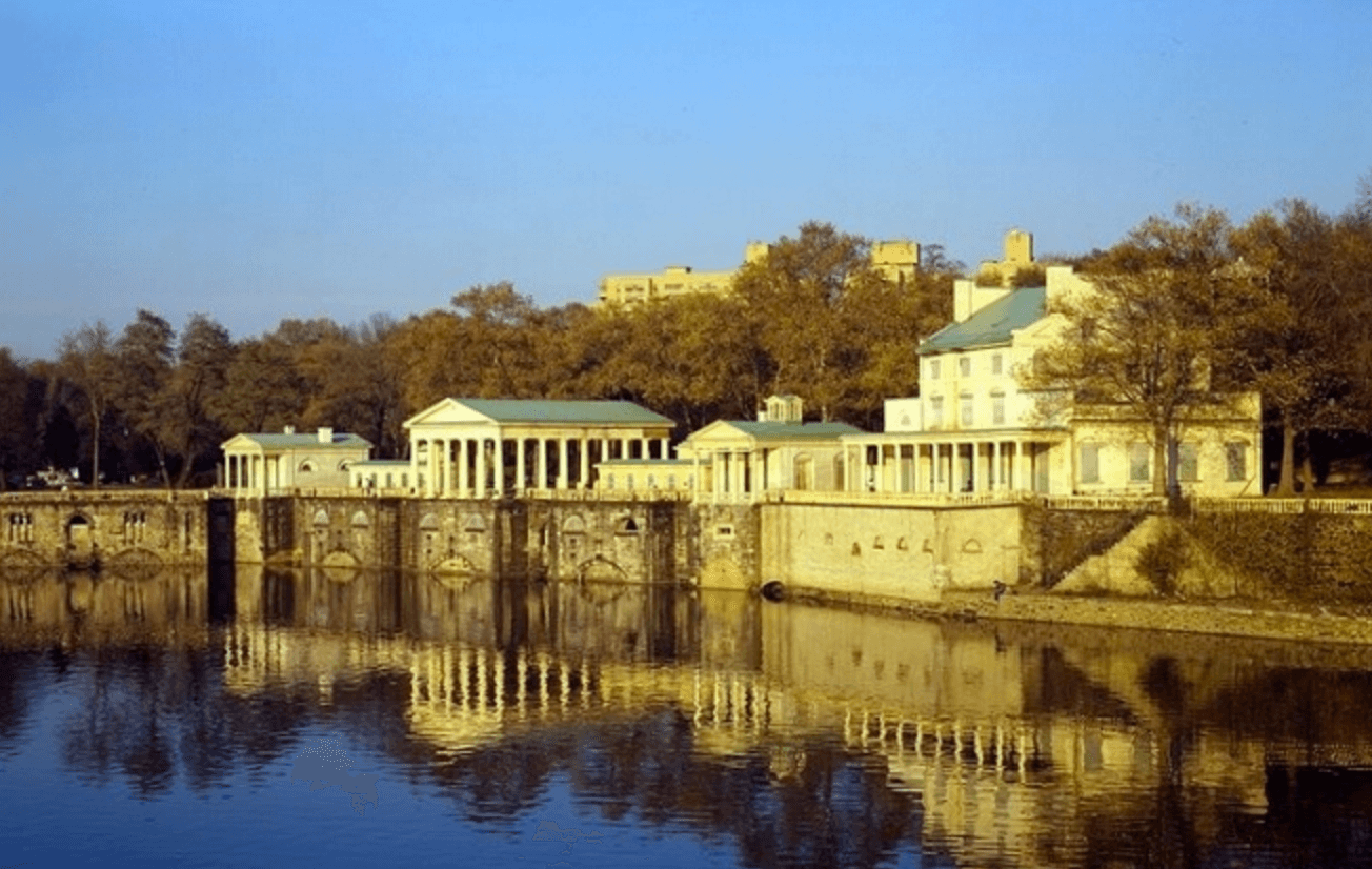 Historic riverside mansion reflected on calm water in Philadelphia