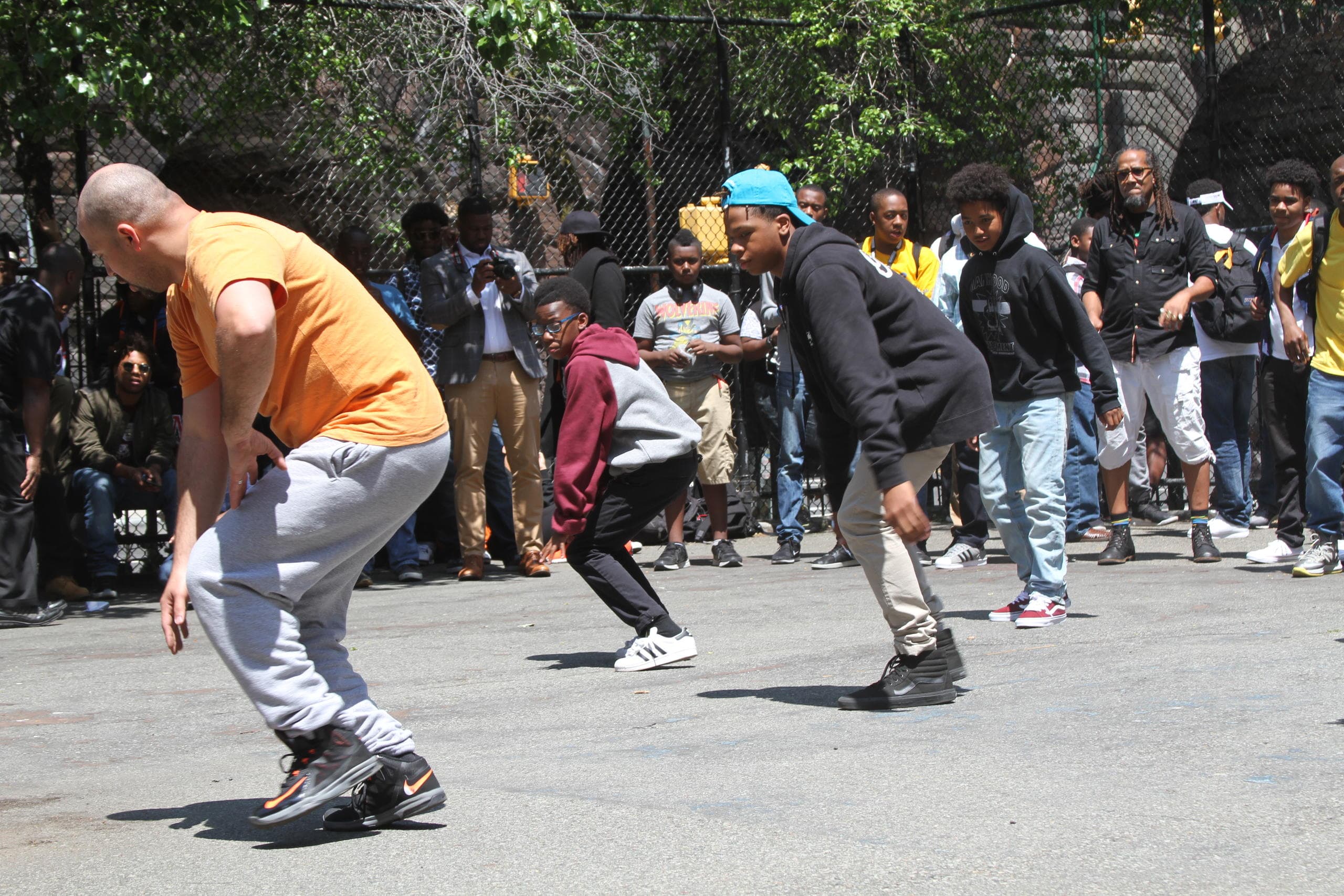Skaters and dancers battling in outdoor basketball court street jam
