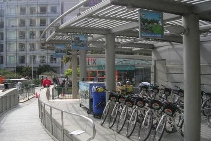 Urban bike share station with rows of rental bicycles at plaza