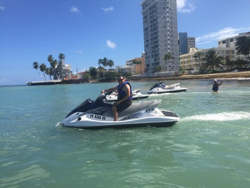 Single jet ski skimming turquoise water near beachfront high-rise
