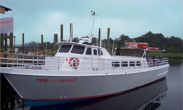 White fishing vessel moored at Little River marina for charters
