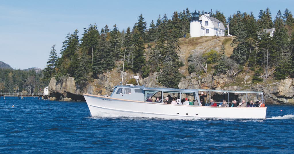Passenger whale watching boat cruising near Bar Harbor coastline