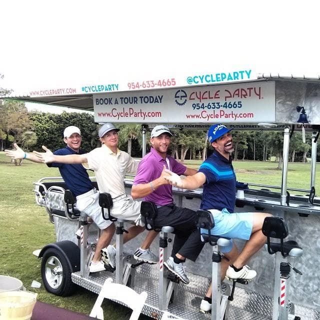 Outdoor pedal pub group riding near green park and clubhouse
