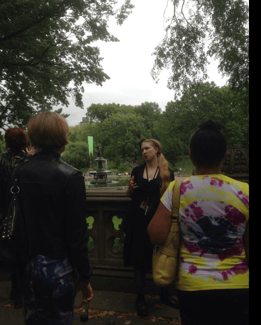 Park walking tour group listening to guide in urban green space tour