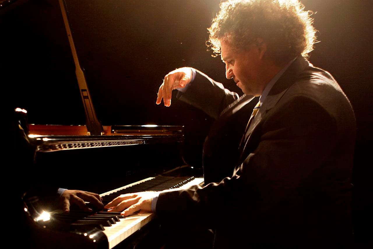 Concert pianist performing under dramatic stage lighting