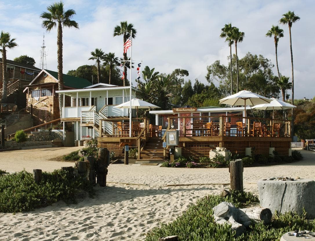 Beachfront cottages and wooden deck overlooking sandy shore