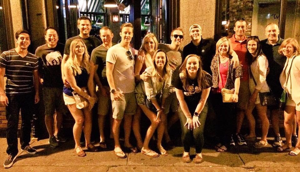 Nighttime large group on city street during guided social pub crawl