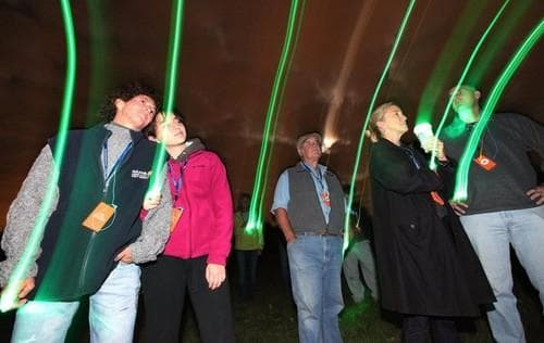 Night outdoor light-walk with neon trails and group participants