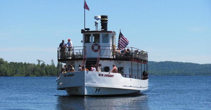 Scenic paddlewheel tour boat on Raquette Lake with flag