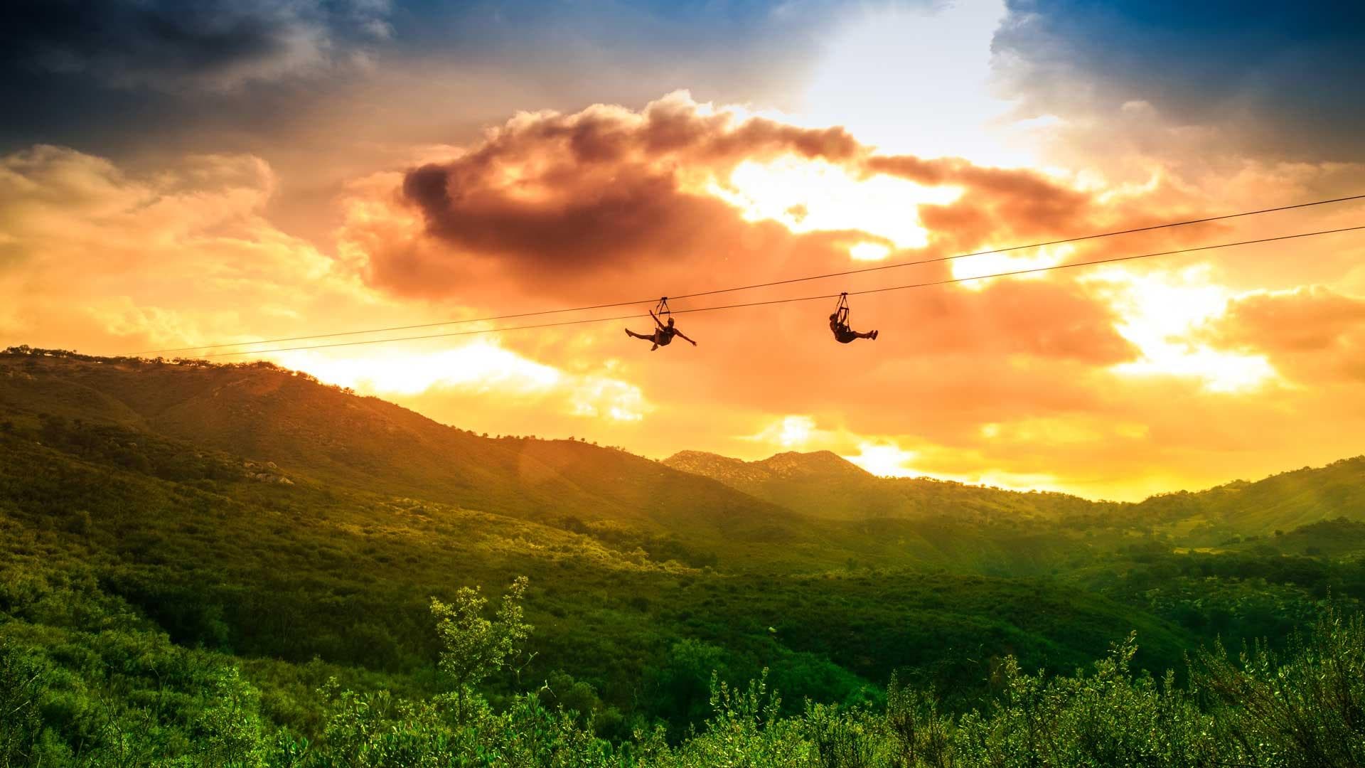 Sunset zipline silhouettes over scenic coastal hills near La Jolla
