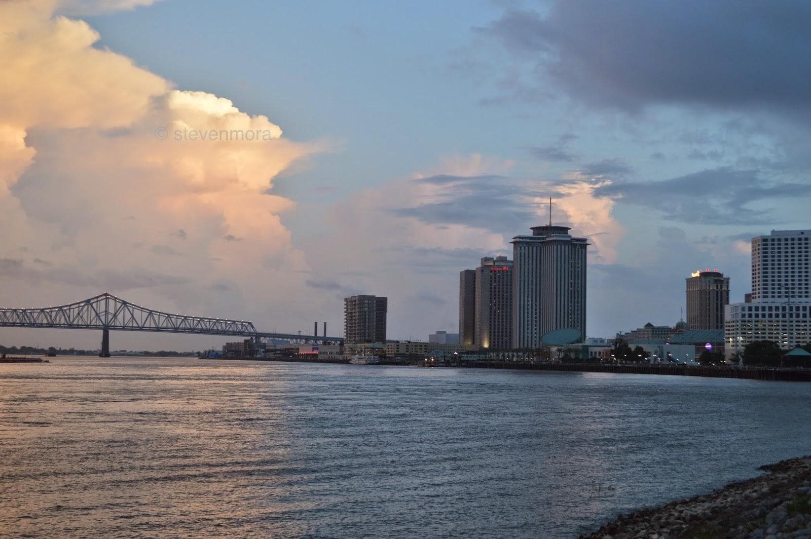 New Orleans skyline at riverfront with calm water sunset