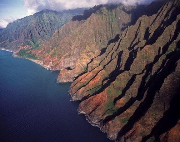 Aerial sightseeing over Na Pali cliffs on Kauai, dramatic coastline