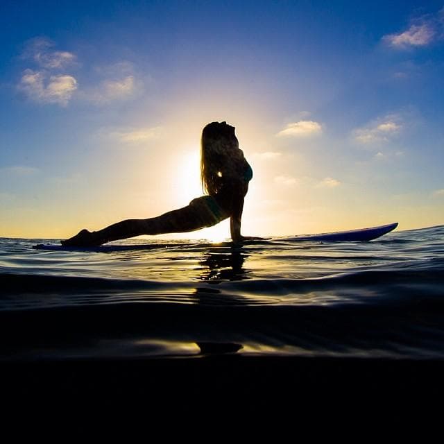 SUP yoga silhouette at sunset on calm lake near Frisco DFW
