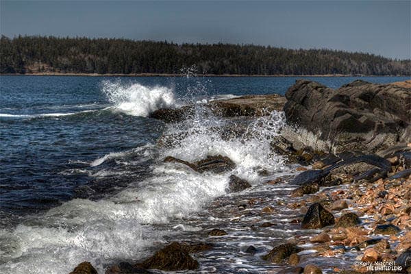 Rocky shoreline with crashing waves along rugged Maine coast